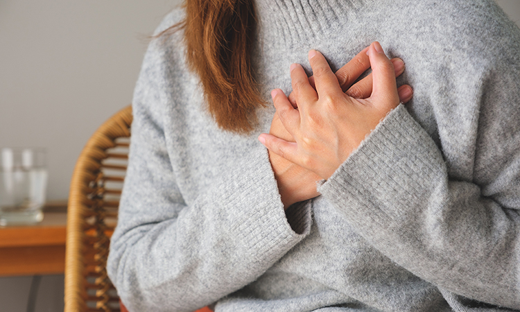 Woman with breast pain touching chest and controlling breast for